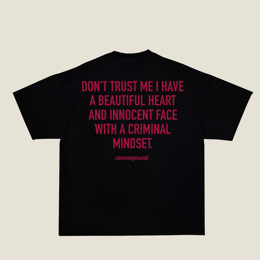 DON'T TRUST ME I HAVE A BEAUTIFUL HEART AND INNOCENT FACE WITH A CRIMINAL MINDSET Tee in black, back print